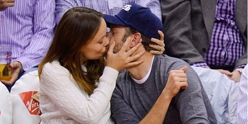 Беременная Оливия Уайлд поцеловала жениха на спортивной игре